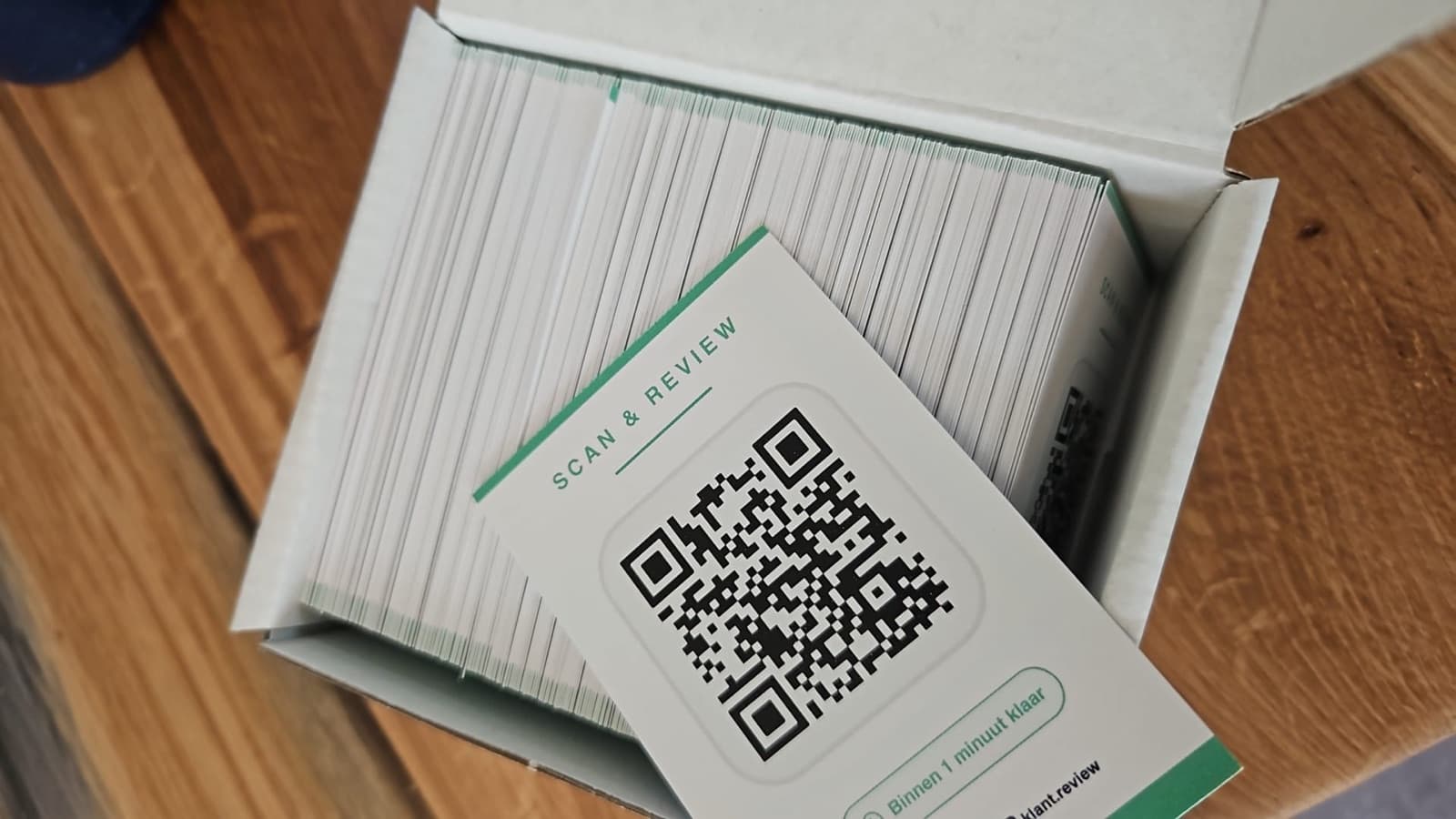 Doos met voorbeeld-QR-review-kaartjes van Soft Sense, bovenste kaartje toont logo en reviewvraag